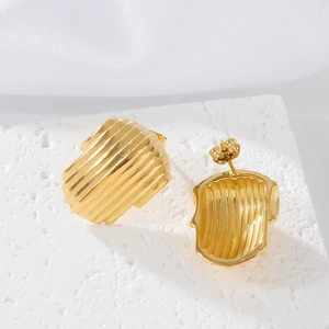 Macro shot of gold-plated stainless steel earrings with shell-style striped texture