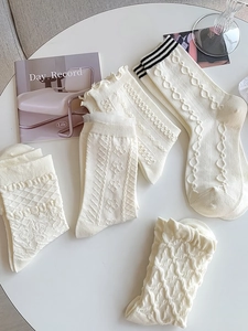 Detailed knit textures and lace edges of various beige JK style mid-calf socks