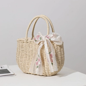 Handwoven straw tote bag featuring a floral lace bow with white pearl accents