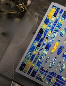 Detailed close-up of The Starry Night inspired nail art stickers with metallic gold finish