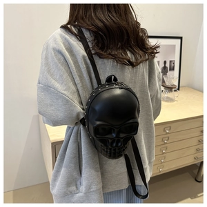 Detailed back view of a 3D skull shaped backpack with rivets and adjustable straps