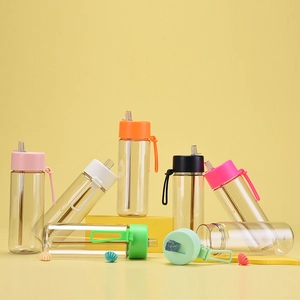Detail of 740ml Tritan straw bottle showing colorful lids and portable silicone handle