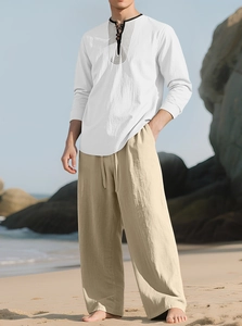 Detail of white linen shirt with black piping and khaki wide-leg pants for beach vacation