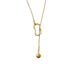 Gros plan sur le collier en acier titane doré avec pendentif anneau et perle