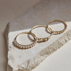 Close-up of S925 silver gold-plated rings with pearls and black stones on a stone base