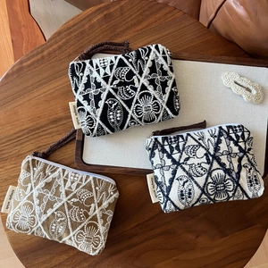 Three handmade cotton linen embroidered coin purses with geometric bird patterns and braided straps