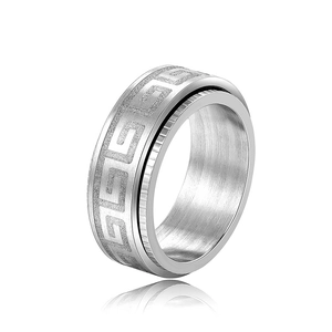 Polished stainless steel spinning ring with Greek key pattern on white background