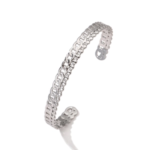 Dettaglio ravvicinato di un bracciale rigido in acciaio argento con trama a catena