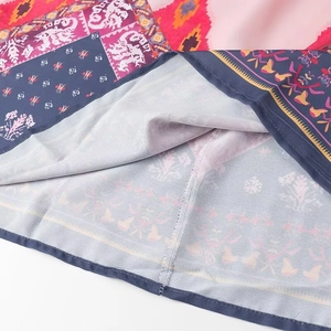Detailed close-up of ethnic print dress hem featuring multi-color fabric and neat stitching