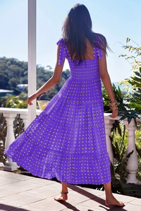 Back view of a purple and yellow plaid maxi dress with shirred waist and thin straps