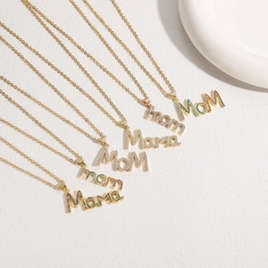 Macro detail of 14K gold plated chain necklaces with zircon Mama and Mom letter pendants
