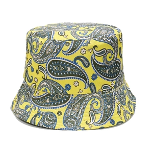Detail of yellow bucket hat featuring intricate blue paisley patterns and canvas texture