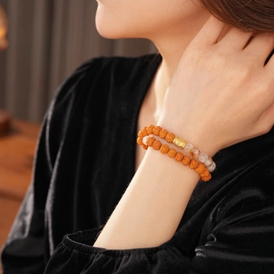 Detail of double-layer Bodhi bracelet with white crystal and golden lucky bead on wrist