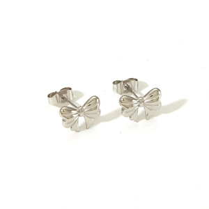 Macro shot of silver bow stud earrings featuring 3D folded texture and butterfly backings