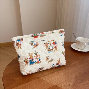 Detailed view of quilted cotton cosmetic bag with rabbit prints on a wooden table