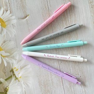 5-piece colorful retractable neutral pen set with motivational quotes on wood background