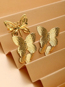 Detailed view of vintage gold butterfly jewelry set with hollow and textured metal designs