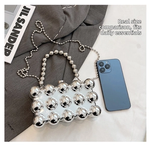Detailed view of silver metallic bead acrylic clutch bag with chain and size comparison
