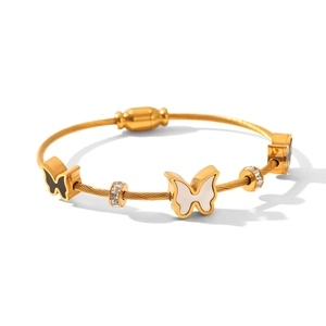 Macro detail of 18k gold plated cable bracelet with white butterfly and crystal charms