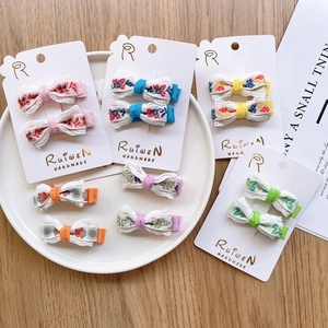 Detailed view of ten handmade floral embroidery hair clips in various pastel colors