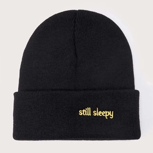 Classic black knitted beanie with yellow 'still sleepy' embroidery for winter warmth