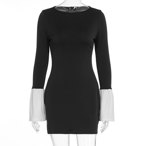Detail view of the flared bell cuffs with contrasting white ruffles on this black mini dress