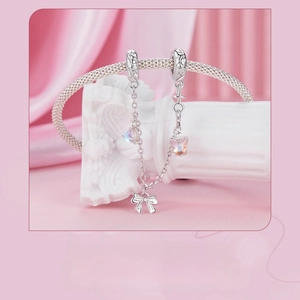 Macro detail of S925 sterling silver bow charm with colorful stones on a silver chain