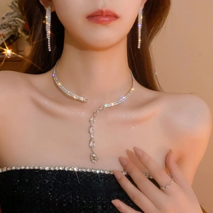 Macro detail of silver necklace set with rhinestones and fringes on a model