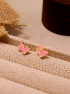 Detail shot of pink butterfly earrings with gold plating on a textured display stand