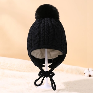 Detail of black knitted baby hat with soft white fleece lining and earflaps for warmth