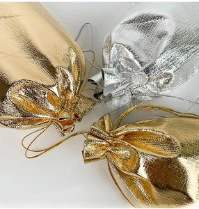 Macro shot of metallic gold and silver jewelry gift pouches with drawstring closure
