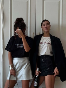 T-shirt bianca oversize con stampa di lettere abbinata a una gonna argento metallizzato