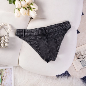 Mini shorts in denim antracite distesi con decorazioni di rose bianche e borsa di perle