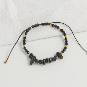 Detail of handmade woven bracelet with black stones, faceted beads and adjustable string