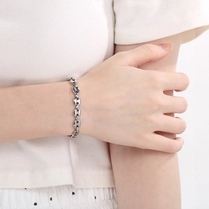 Close-up of a silver coffee bean link bracelet worn on a wrist for elegant styling