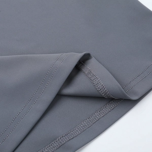 Zoom sur l'ourlet à double couture et le tissu en maille grise de cet ensemble de sport