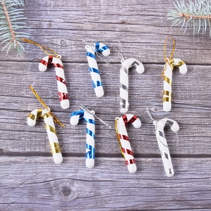 Set of 8 colorful 7cm Christmas candy cane hanging ornaments on a rustic wood background
