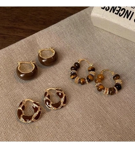 Detail view of ethnic retro tiger eye beaded earrings set in brown and gold finish