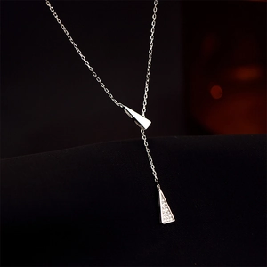 Detalle de collar en Y plateado con colgantes triangulares pulidos y engaste pavé