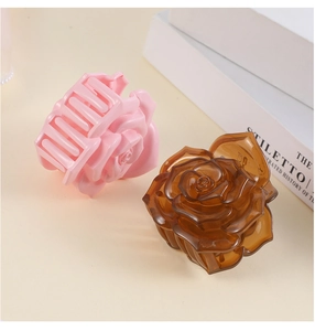 Détail de pinces à cheveux rose 3D en résine rose et ambre montrant la texture des pétales