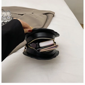 Detailed internal view of small crossbody bag showing storage capacity for essentials