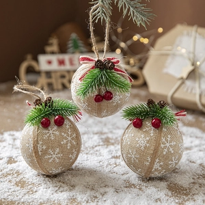 Plaid burlap Christmas ornaments with pine needles and pinecones on a snow backdrop