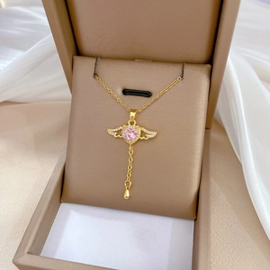 Elegant gold titanium necklace featuring pink heart wings pendant on white silk background