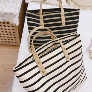 Detailed view of quilted striped canvas tote bags with leather handles and rivets