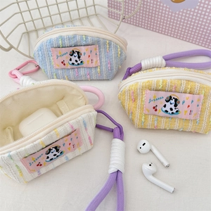 Detailed macro view of woven stripe earphone pouches with cute cartoon dog patches