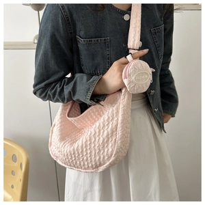 Pink pleated cloud bag with small round coin purse shown on a person for size