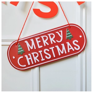 Close-up of red metal Merry Christmas sign with green tree icon on white background