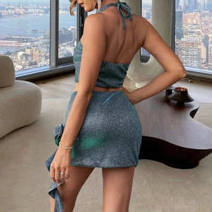 Deep green sequined two-piece set featuring backless halter top and asymmetrical mini skirt