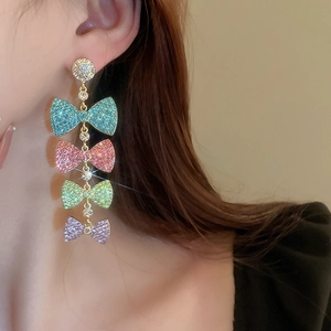 Detail of four-tier crystal bow tassel earrings with colorful rhinestones on a model