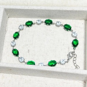 Bracelet élégant avec émeraudes ovales, pierres de zircon et chaîne d'extension argentée